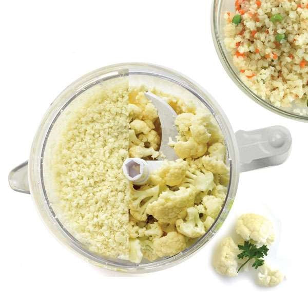 top view of food processor mixer with half diced cauliflower and half cauliflower pieces