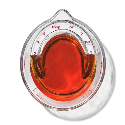 top view of tiny measuring cup for the kitchen with syrup