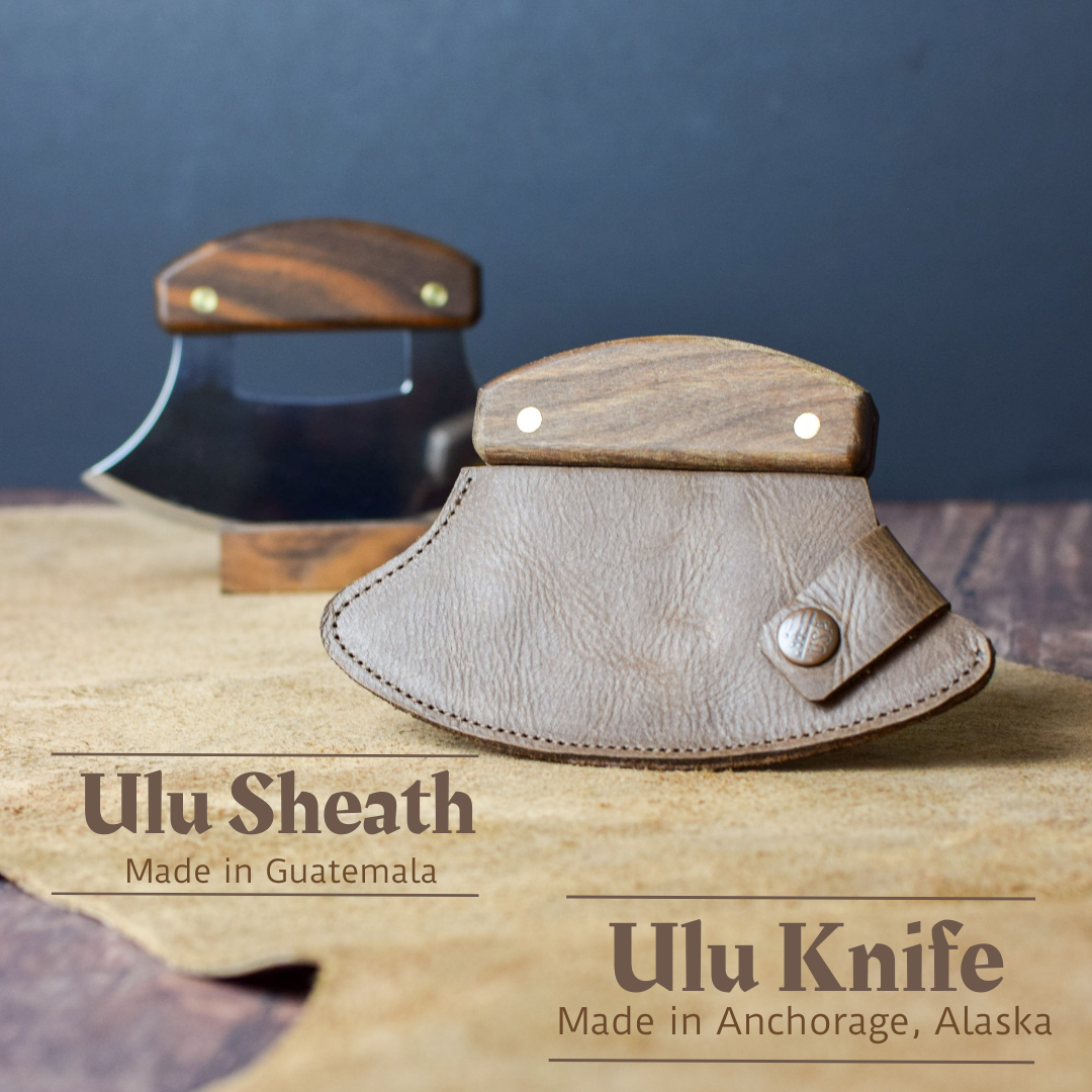 Alaskan Ulu knife with walnut handle sitting on wood stand with leather sheath cover in front